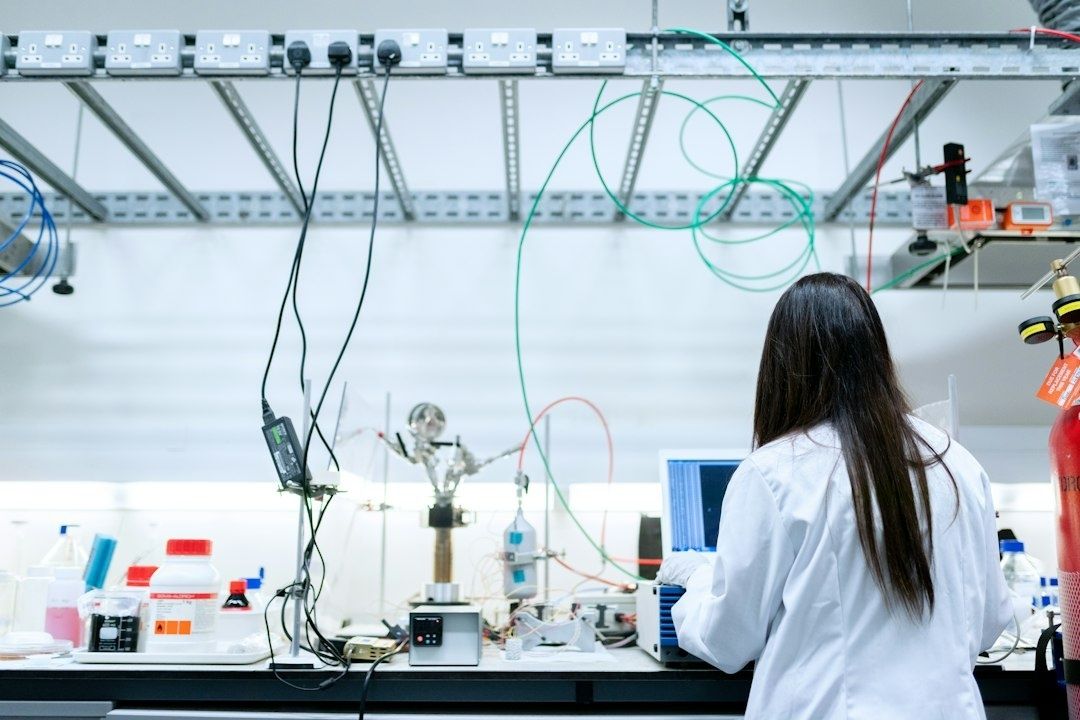 Forskare i labbrock arbetar vid mätutrustning och dator i laboratorium